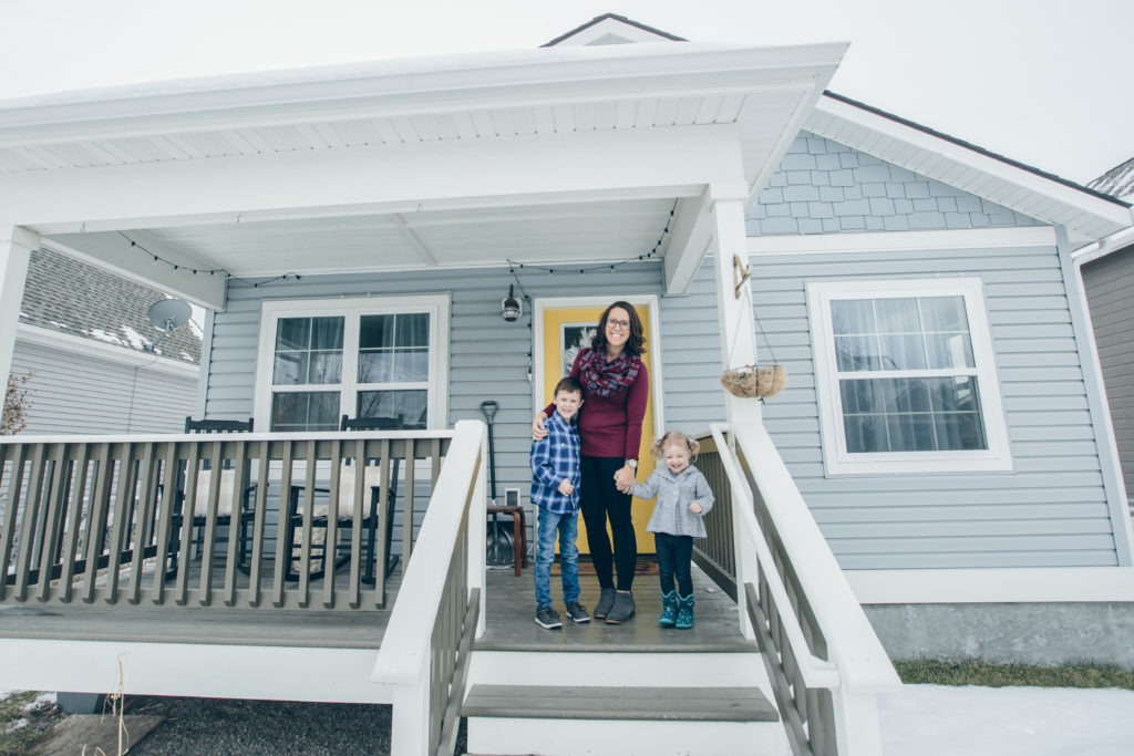 Family in front of home purchased with down payment assistance